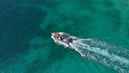 Aerial drone photo of inflatable power boat cruising in high speed in tropical exotic emerald clear sea