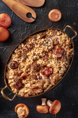 Risotto ai funghi, mushroom rice, with ingredients, top shot on a dark background