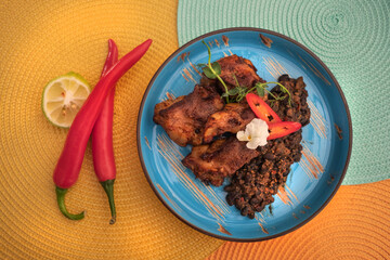 Street mexican food on the table. Braised ribs and beans. Top view. Microgreens, pepper and lime. . High quality photo