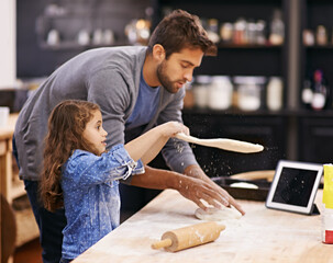 Shes got talent. Shot of a father and daughter working with pizza dough in the kitchen.