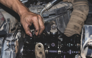 The mechanic is checking the engine.