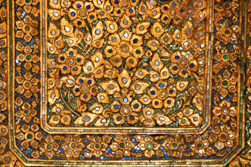Golden Pattern at Wat Pho in Bangkok, Thailand with Floral Design of shapes and color. Vintage thai golden pattern with gems. Asian golden ornament in Thailand. Traditional decorative background