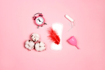 Sanitary napkin, tampon, menstrual cup, cotton and feather on pink background. Different types of feminine hygiene products.