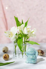 Easter bunny, quail eggs and spring flowers on the pink background. Festive easter vertical card with free text space