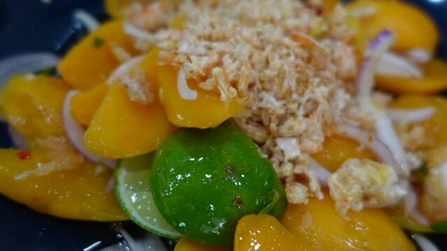 Marian plum or plango tropical sweet and sour fruit in Thai spicy lime salad with dried shrimp tasty thai food