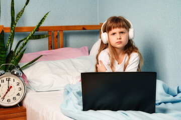 Girl child sit on bed behave bad demand laptop battle, listening to music