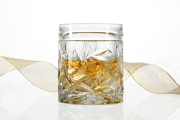 Glass of whiskey with a yellow ribbon isolated ano whithe background with copy space for your text