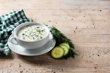 Bulgarian tarator sour milk soup in bowl on wooden table. Copy space