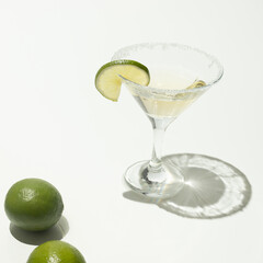 Martini glass with vermouth, sugar and lime slice. Flat lay. White background. Creative minimal concept.