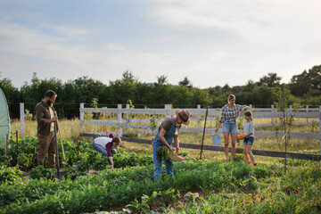 Happy farmers or gardeners working outdoors at community farm.