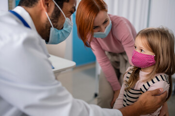 Little girl with her mother at doctor's office on consultation, coronavirus concept.