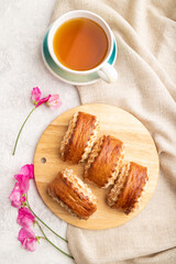 Traditional armenian dessert gata with cup of green tea on a gray concrete background. top view, close up.