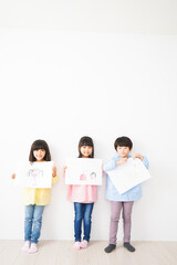 Naklejka premium 自分で描いた絵を見せる小さな子どもたち