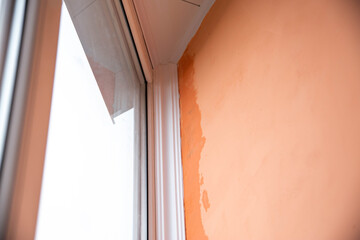 Rain dripping in the corner on the balcony between the window frame and the wall. Damage to walls due to poor quality repairs. Copy space for text