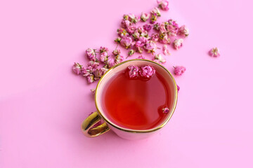 Flower tea with rose buds on gray textured background .Dried tea roses flowers 