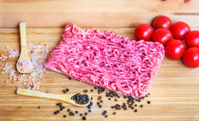 Ingredients for Lasagna or Bolognese Sauce .Pork Mince ,Cherry Tomatoes, Red Onion and Basil on a Wooden Background 