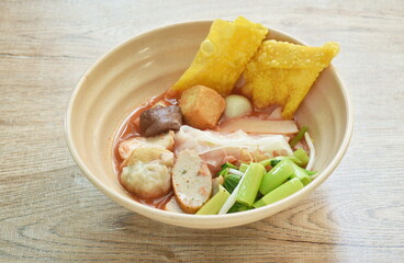 rice noodles with fish ball and tofu topping crispy squid in red soup