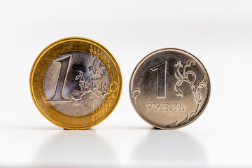Pièces de 1 euro et de 1 rouble sur fond blanc. Concepts de taux de change, de transactions...