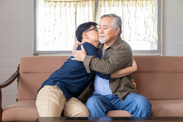 Senior Asian man embracing and listening to bad news from his son who just lost a job and come back home seeking for consolation and empathy from father with copy space
