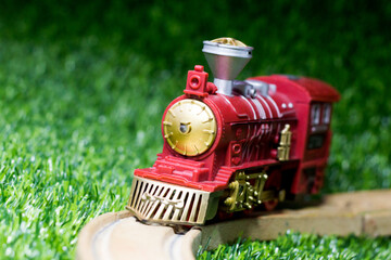 Toy train and rails on the grass in the garden