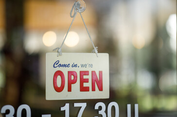 open sign door Text on vintage black sign "Come in we're open" in the cafe.