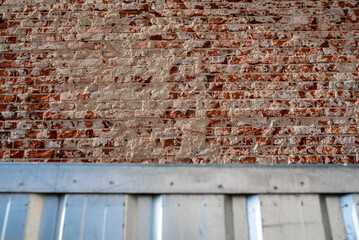 Scratched facade showing old red brick 