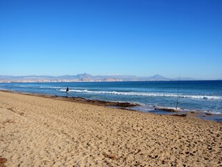beach with horse and rider and fishing rod