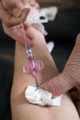 Nurse's hand removing an IV drip to a patient