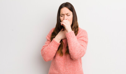 pretty caucasian woman feeling ill with a sore throat and flu symptoms, coughing with mouth covered