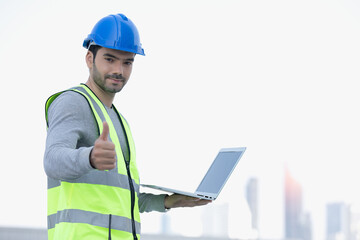 Smart engineer maintenance in solar power plant checking installing photovoltaic solar modules with laptop doing happy thumbs up gesture with hand. Concept of sustainable resources, saving energy.