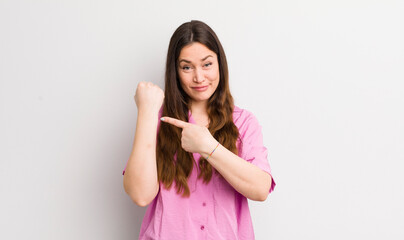 pretty caucasian woman looking impatient and angry, pointing at watch, asking for punctuality,...