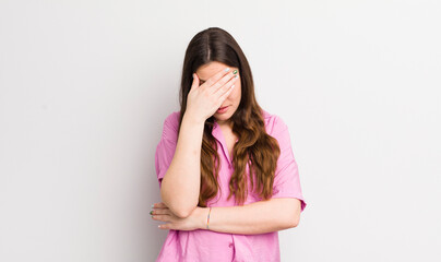 pretty caucasian woman looking stressed, ashamed or upset, with a headache, covering face with hand - obrazy, fototapety, plakaty