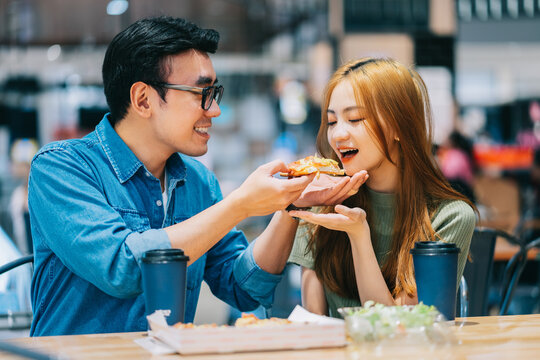 Young Asian couple having lunch together in cafe