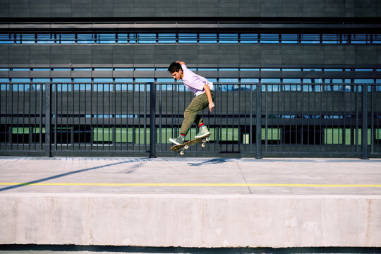 A teenage boy performs tricks on a skateboard.