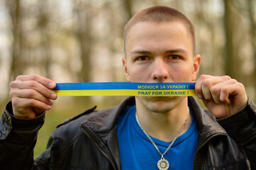 ukrainian guy with a ribbon on which is written pray for ukraine, Kyiv, flag of ukraine, young serviceman, war in Ukraine