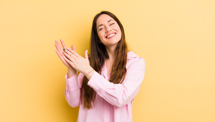pretty caucasian woman feeling happy and successful, smiling and clapping hands, saying...