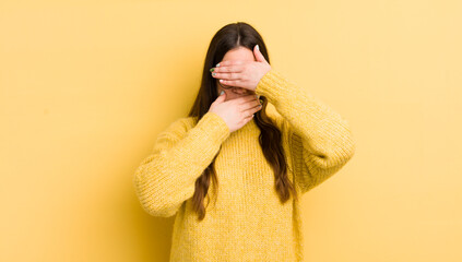 pretty caucasian woman covering face with both hands saying no to the camera! refusing pictures or...