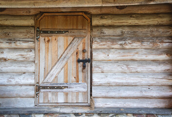 Old wooden door with a metal lock in a rustic log house, antique. Copy space for text