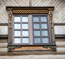 A beautiful square window with carved shutters. Rustic decoration, close-up