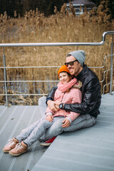 Father and daughter hug each other, have fun and laugh outside in autumn