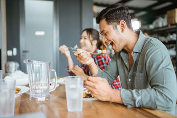 asian young people eating lunch together in the kitchen