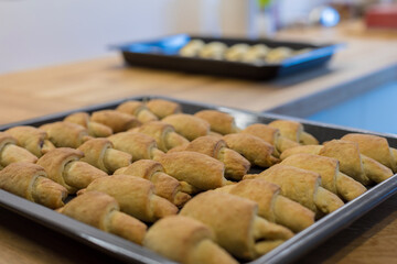 Fresh crispy croissants on a baking tray