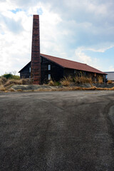 まっすぐに空に伸びるレンガの煙突のある古びた陶器生産工場