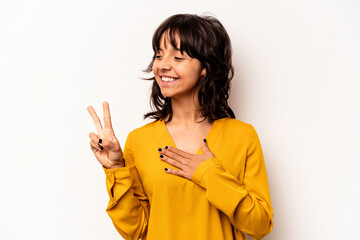 Young hispanic woman isolated on white background taking an oath, putting hand on chest.