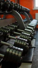 Obraz na płótnie Canvas Fitness or bodybuilding concept background. Product photograph of old iron dumbbells on grey, conrete floor in the gym. Photograph taken from above, top view with lots of copy space