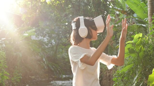 VR application test Asian child girl with virtual reality glasses headset touching air during the VR experience, Beautiful woman touch something using modern virtual reality glasses.