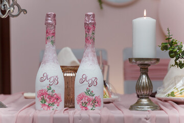 Decorated pink wedding presidium for just married, event organization. Beautiful flowers, champagne bottles, candles close up