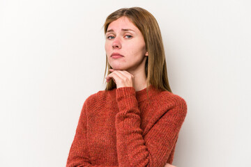 Young russian woman isolated on white background suspicious, uncertain, examining you.