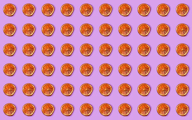 Regular arrangement of Dissected orange slices on a violet surface.