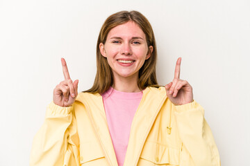 Young English woman isolated on white background indicates with both fore fingers up showing a...